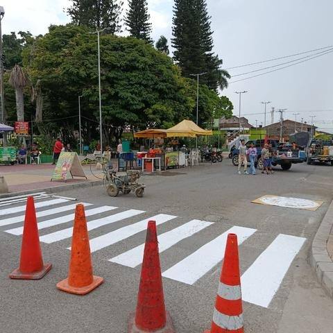 Pintura de cebra peatonal con conos de seguridad en una vía urbana
