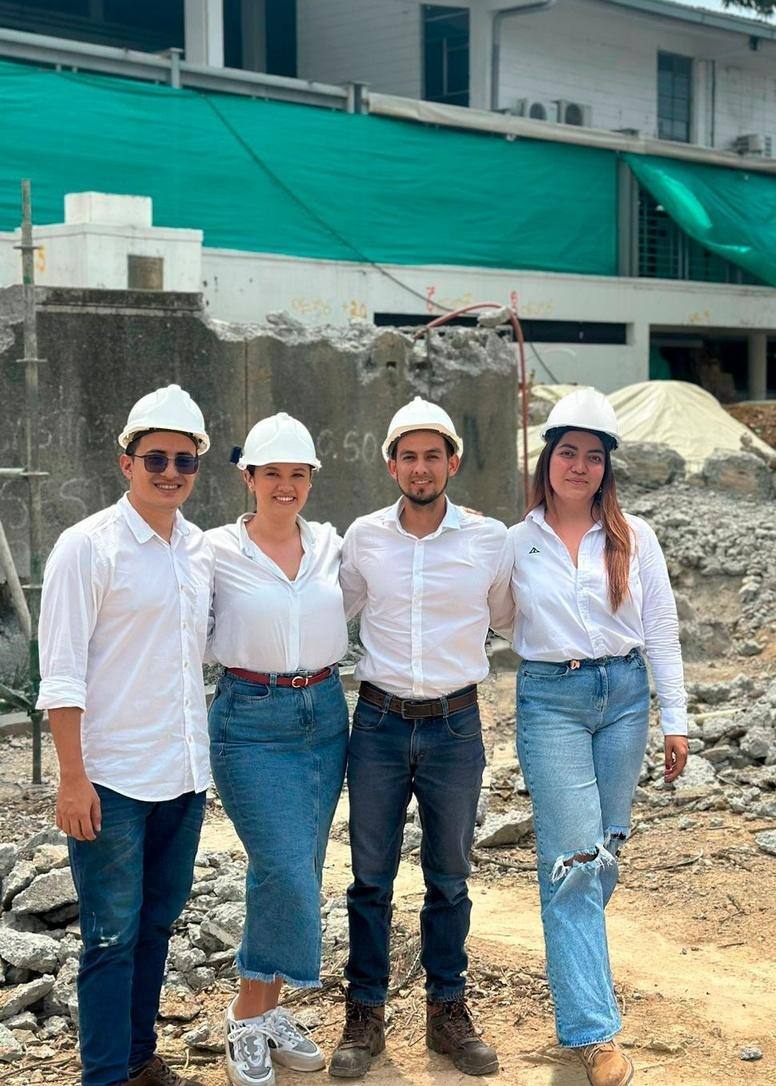 Equipo de ingenieros y arquitectas de QUATTRO con casco en una obra de Cali