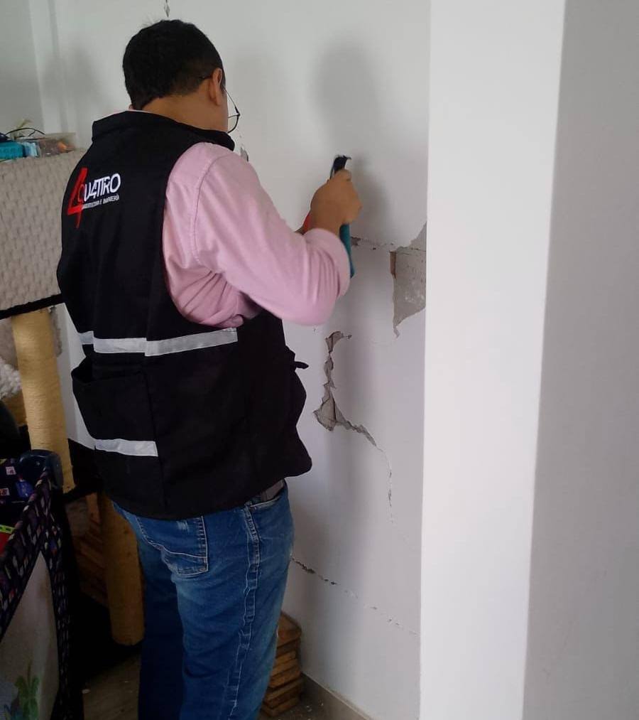Ingeniero de QUATTRO inspeccionando una fisura en un muro de apartamento después del sismo en Cali