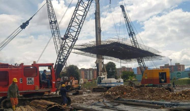 Grúa izando una parrilla de acero de refuerzo en obra