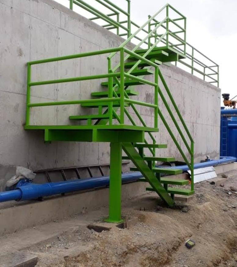 Escalera metálica industrial con barandas pintadas