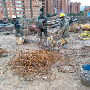 Obreros figurando acero de refuerzo para pilotes en una obra