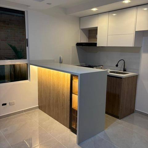 Cocina abierta remodelada con barra y acabados en madera