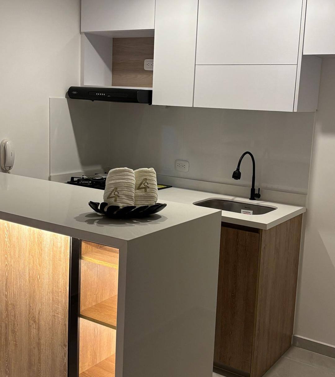 Cocina remodelada con mesón, iluminación LED y muebles en madera