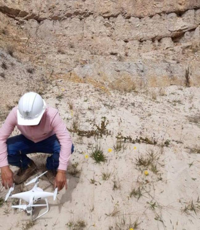 Topógrafo preparando un dron para un levantamiento fotogramétrico